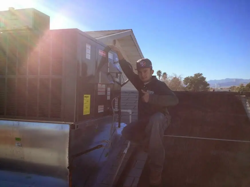 HVAC technician performing Air Duct Cleaning on a rooftop unit in Fort Wright